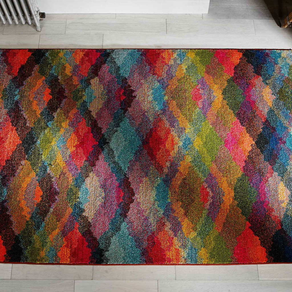 multi-coloured kaleidoscope prism rug against a white wooden floor for a prize as a pinterest competition