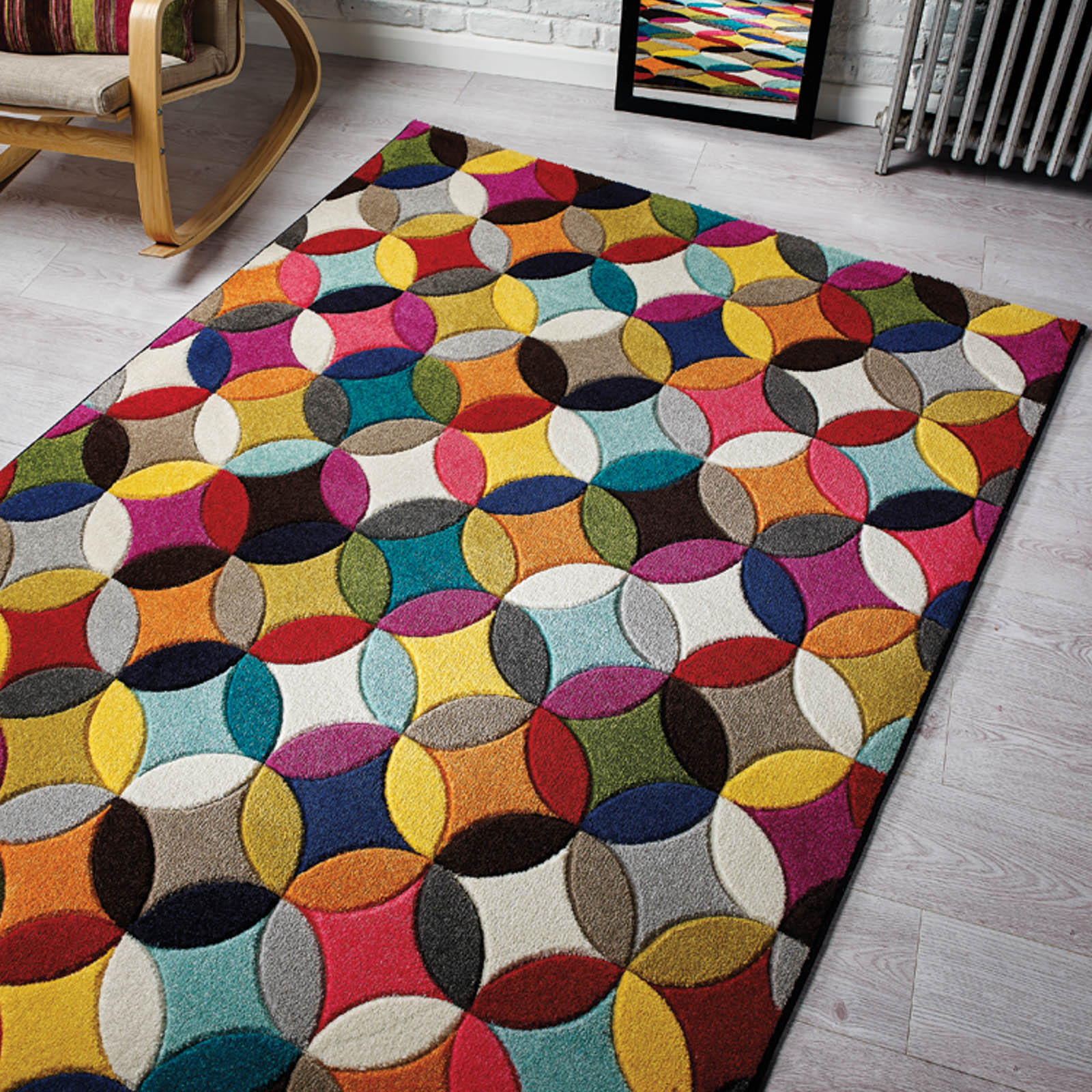 A multicoloured, circular design floor piece on a ligth grey coloured flooring