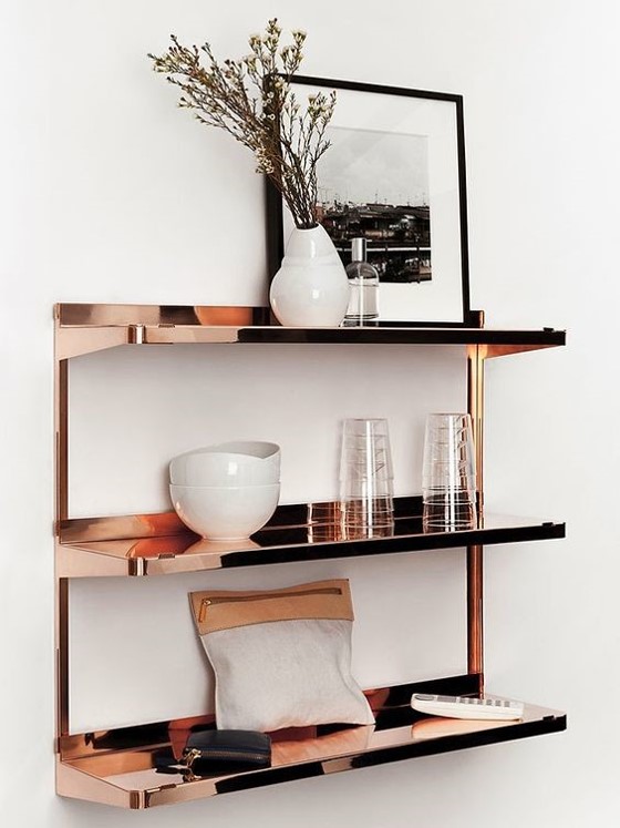 copper shelving with a variety of white accessories on a white wall for copper interiors
