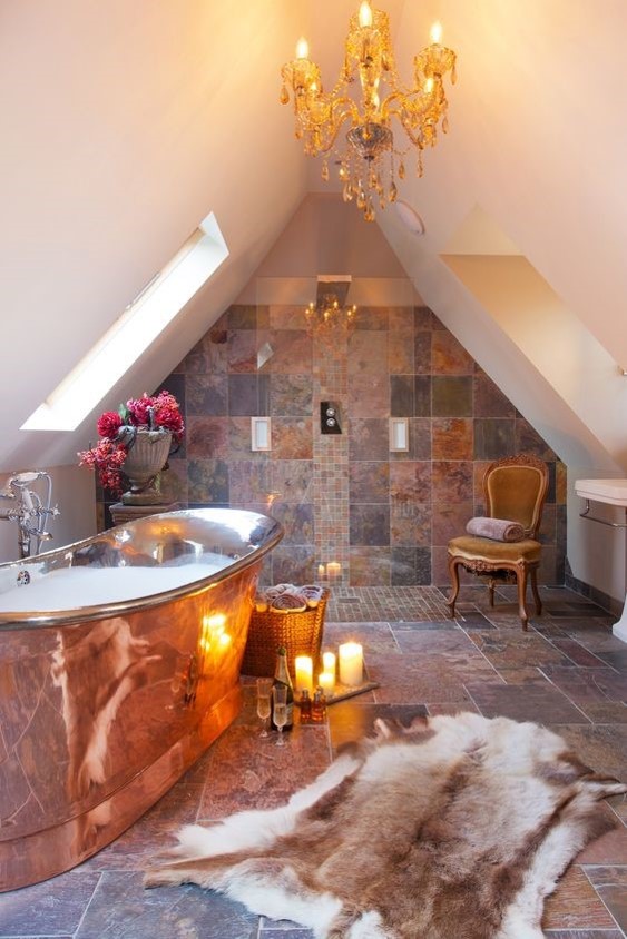 marble tiled bathroom lit with candles with a large freestanding copper bath for copper interiors
