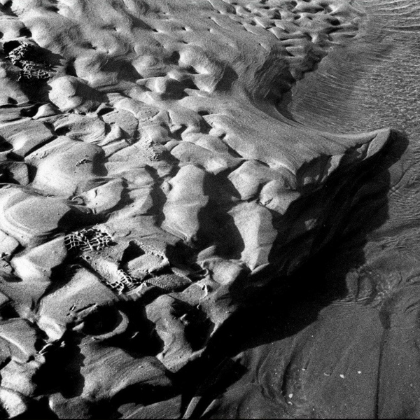 Black and white landscape photography of soft rocks surrounded by water