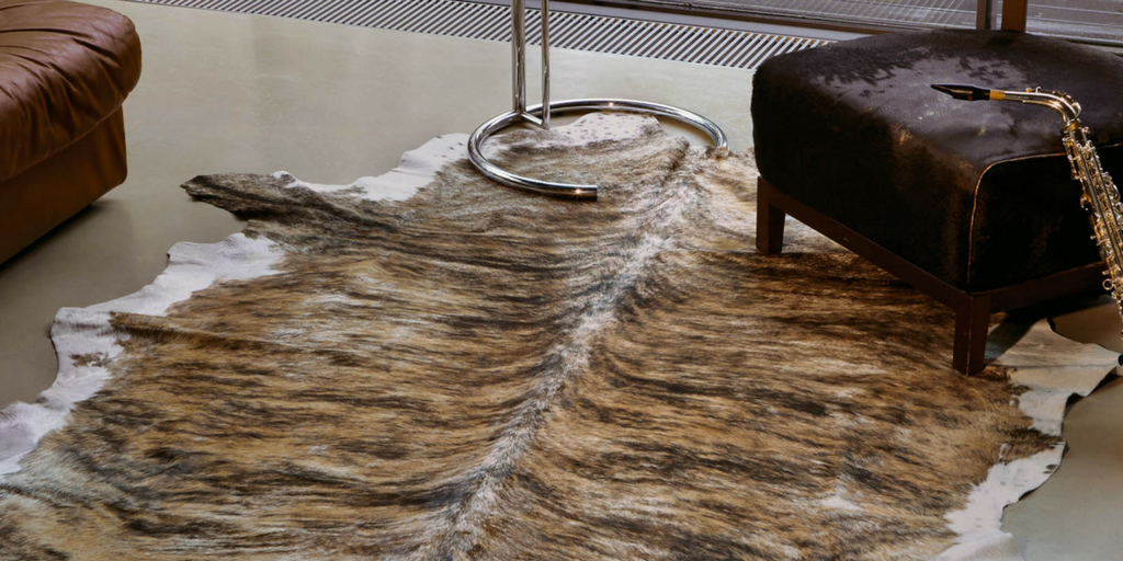 style faux fur real cowhide rug in brown and cream on a wooden floor