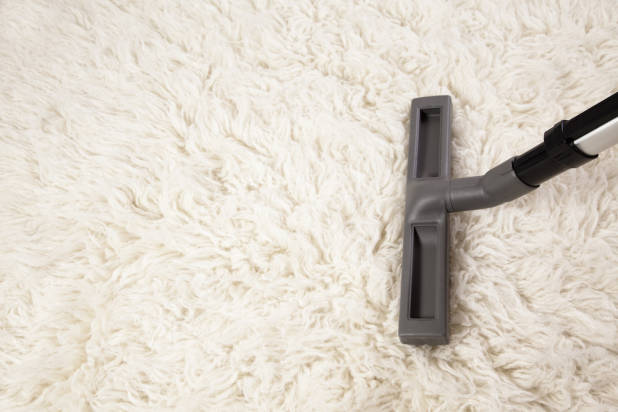 plain white shaggy rug being hoovered - rug care guide