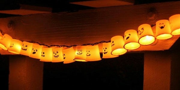DIY halloween decorations of plastic cups with creepy faces attached to string lights