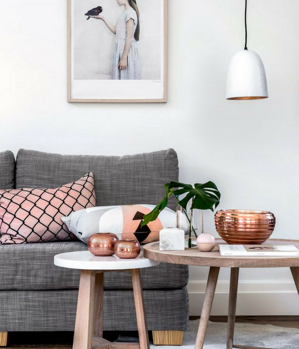 blush pink living room with a pink cushion and copper accessories