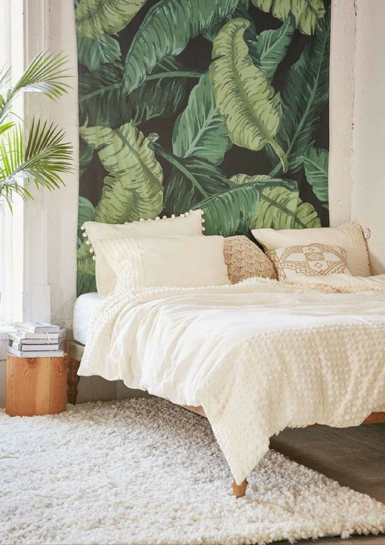 a bedroom with a botanical feature wall 