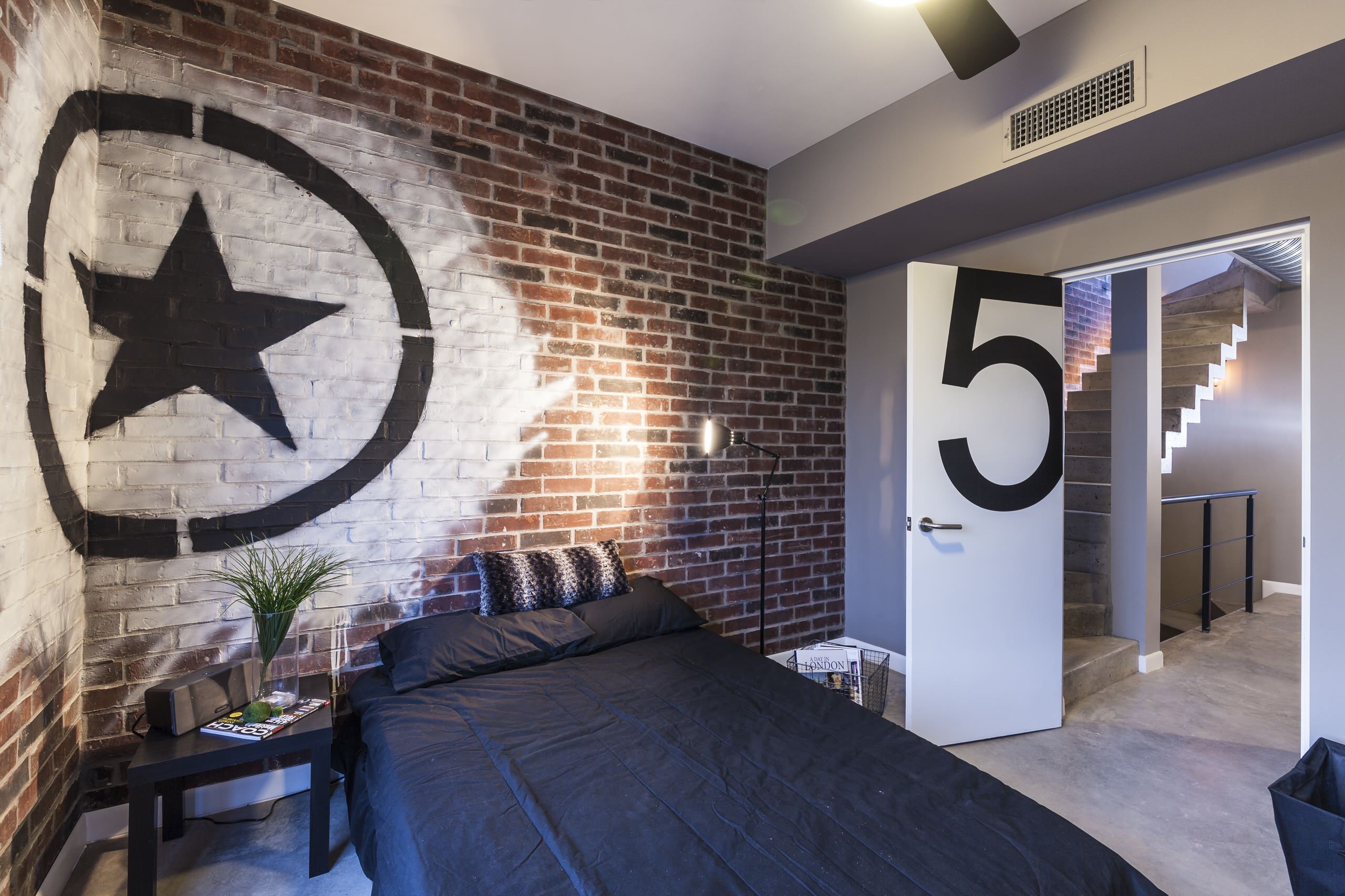 industrial style bedroom with white artwork on exposed brick