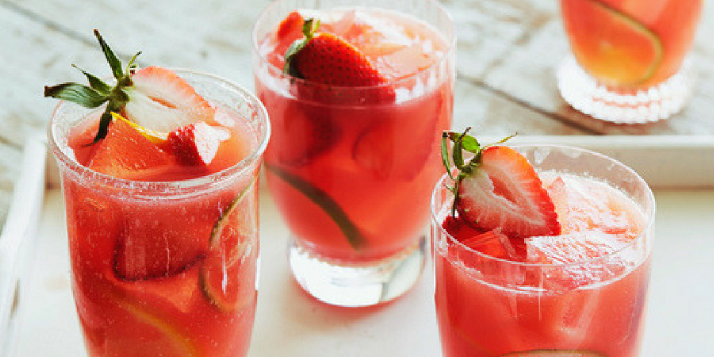 glasses of red coloured sangria with strawberries and ice inside