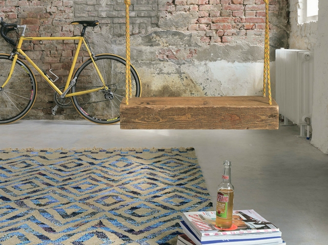 an industrial loft interior with a vintage bicycle and a blue tika rug