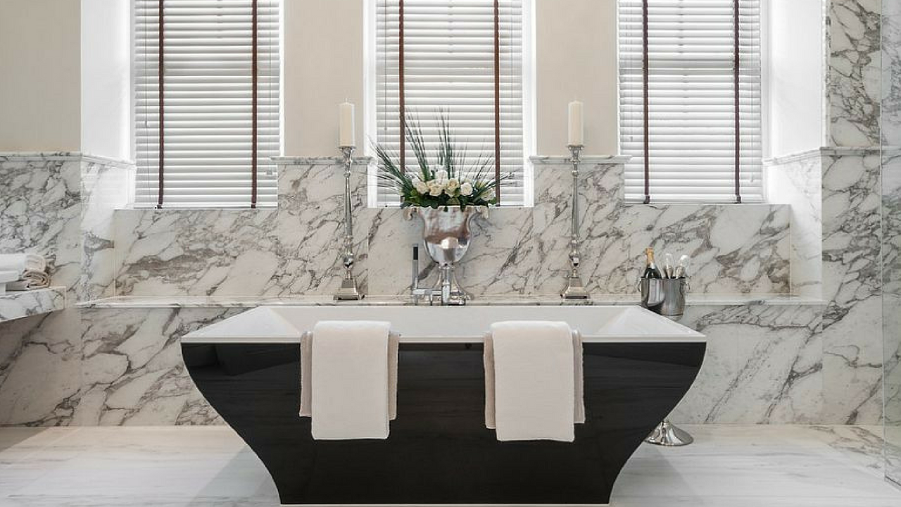 dark colours marble walls and black bathtub in a large bathroom