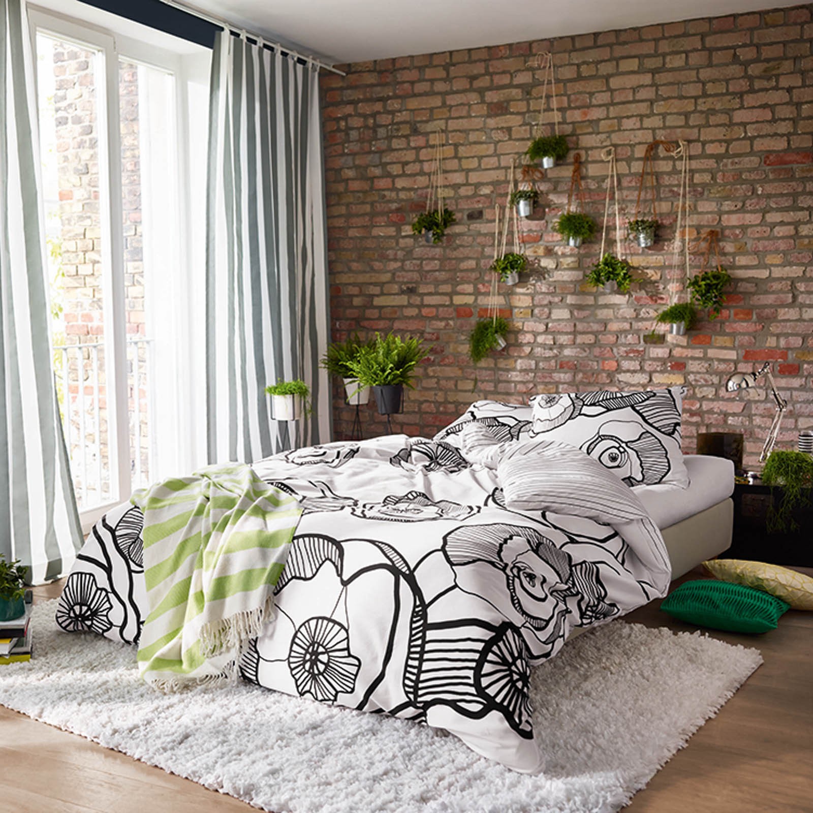 beddroom with bed near window with exposed brick wall