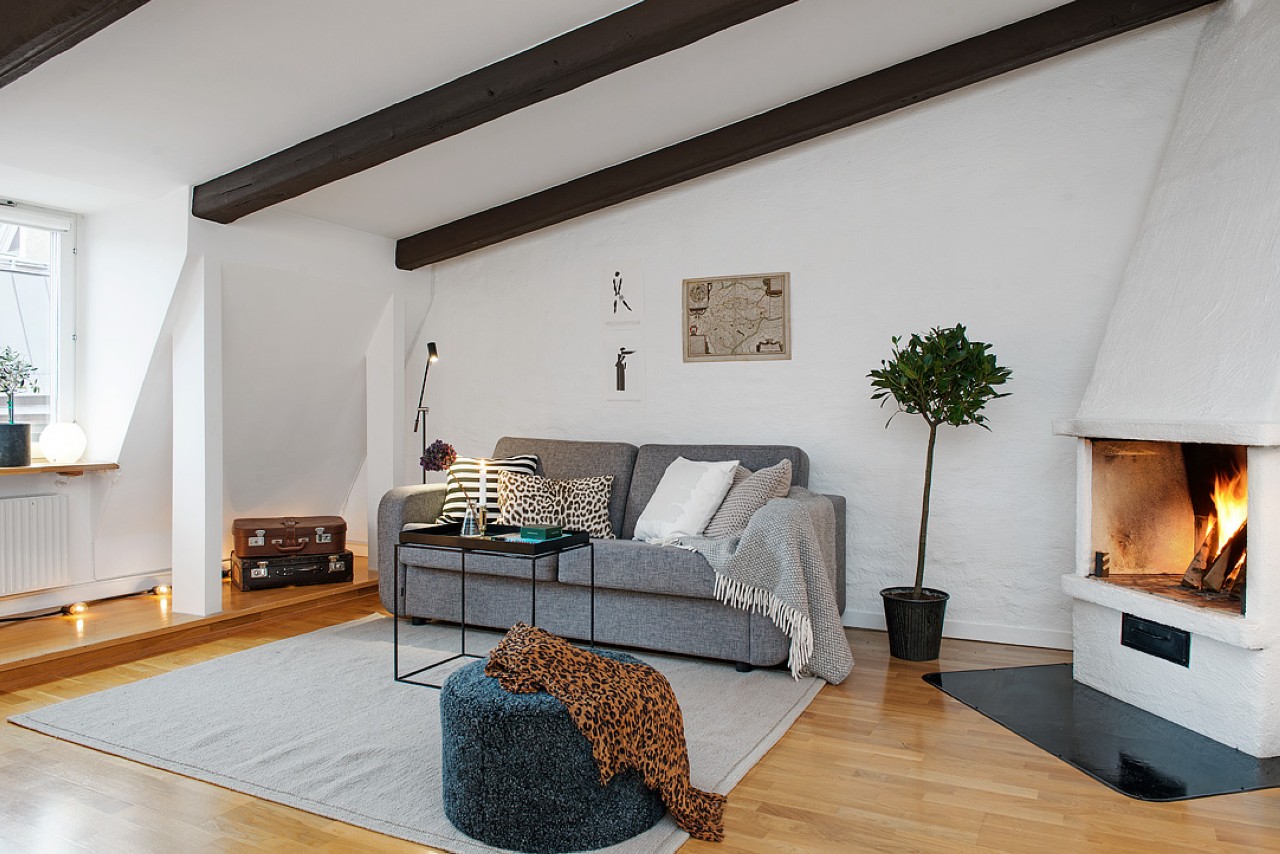 scandinavian interior with a couch and fireplace a pouffe