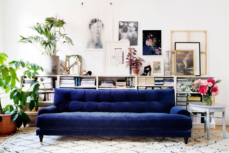 dark blue velvet couch in a rustic overly decorated interior