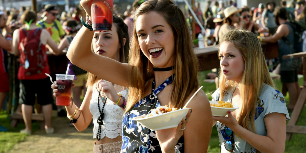 festival essentials girl smiling whilst holding her chips