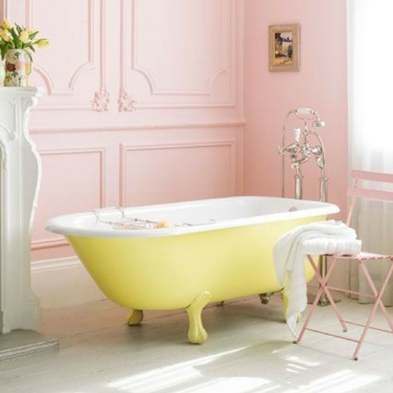 Yellow and bright bathtub in a pastel pink coloured bathroom