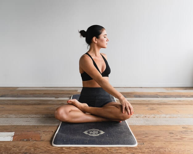woman on a mat in the Padmasana pose
