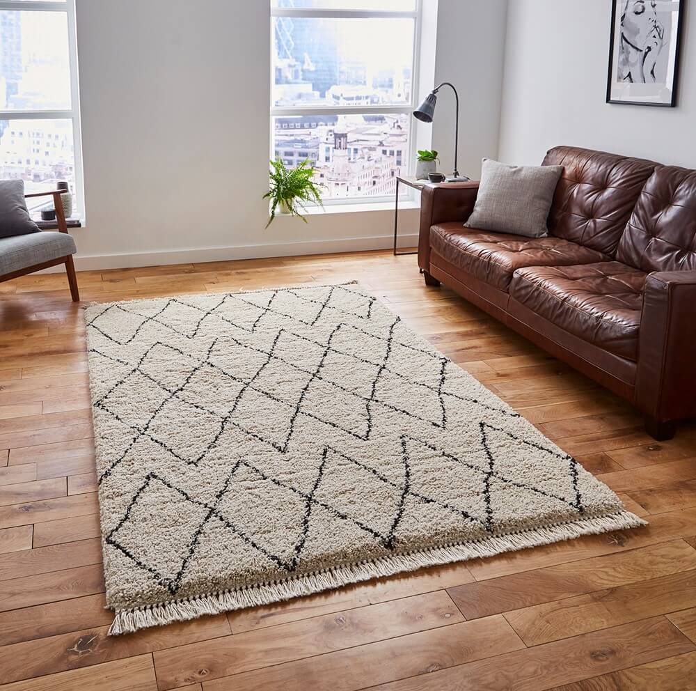 boho style of rug in the middle of a brightly lit living room on a wooden floor