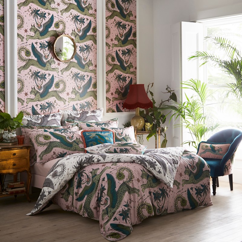 the pink and green lynx and peacock bedding set on a bed in a bedroom 