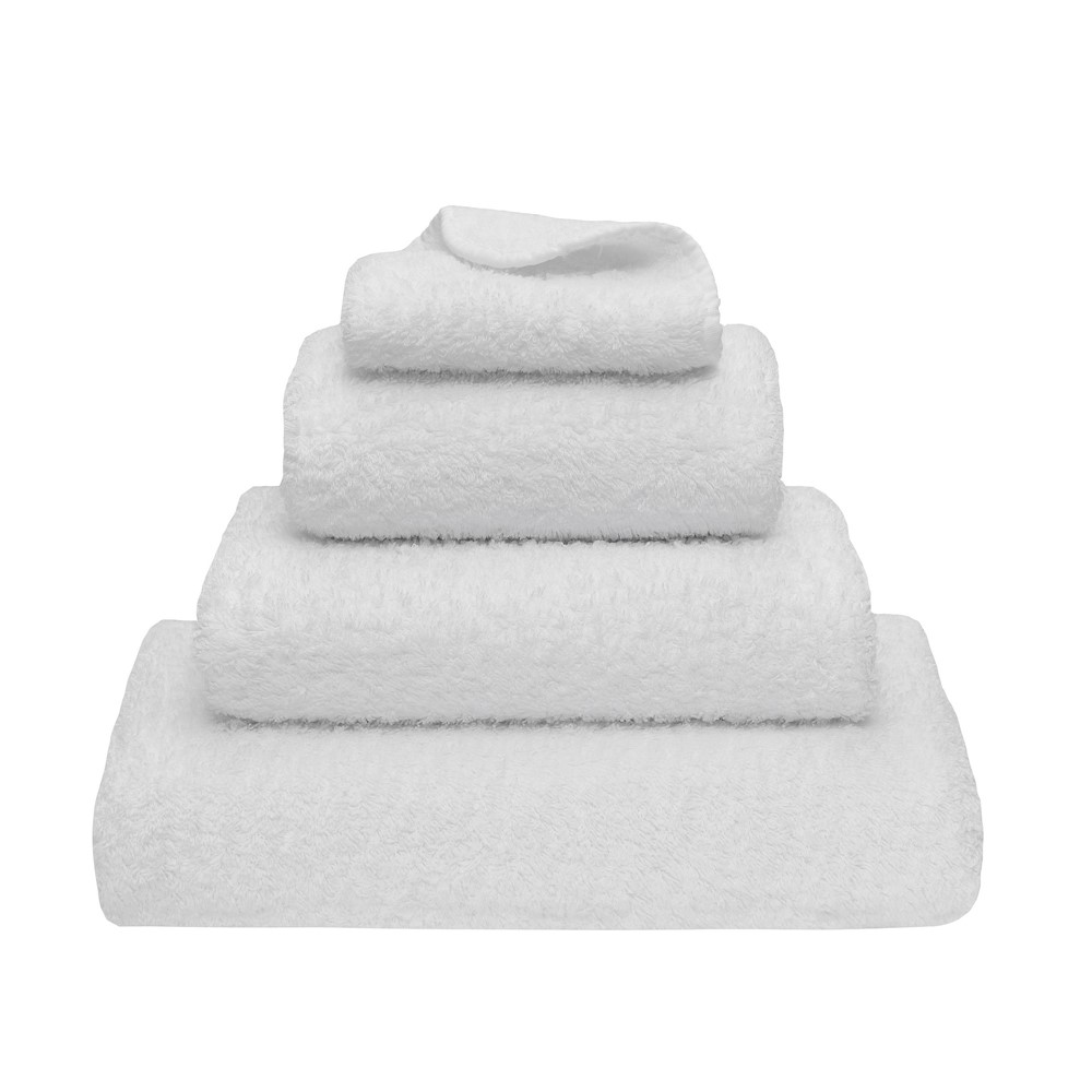 super pile white towels stacked on top of each other against a white background