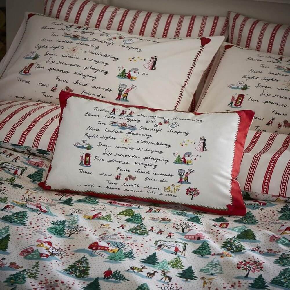 a festive accessory cushion by cath kidston featuring the twelve days of christmas poem, set on the matching bedding set