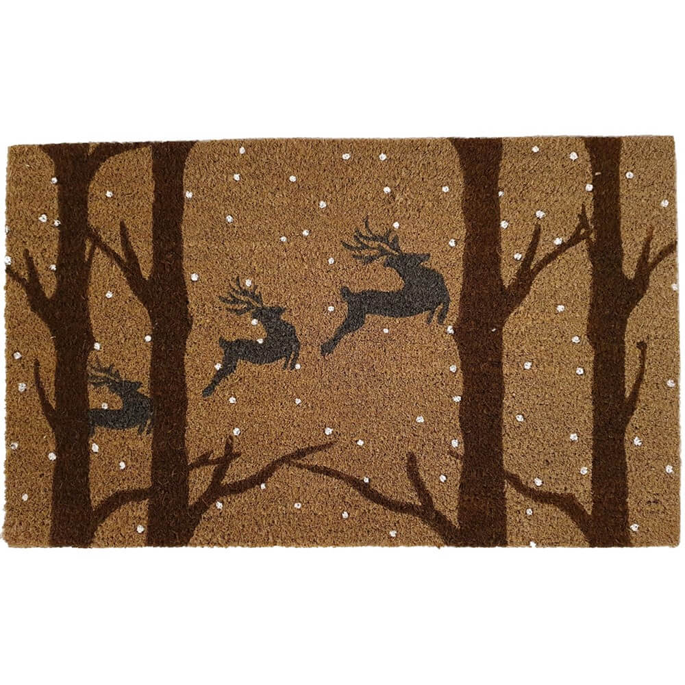 a natural coir festive accessory doormat with images of woodland trees, snow and flying reindeer
