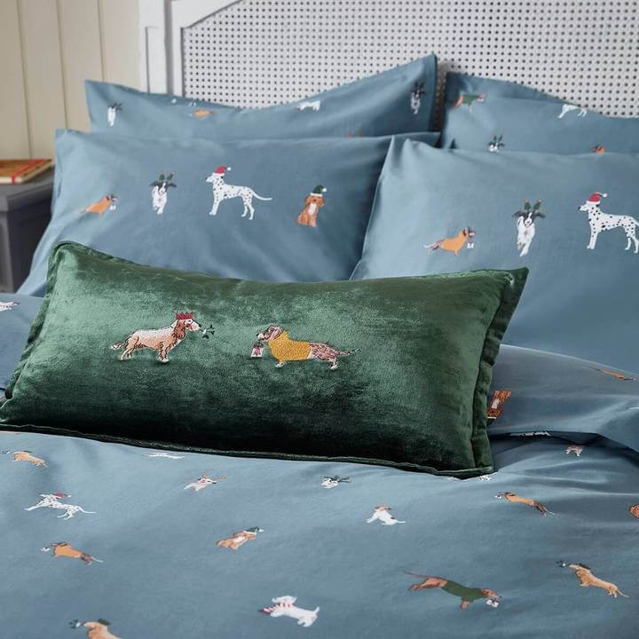 last minute christmas accessories with the green velvet sophie allport cushion with christmas dogs on a bed with the matching bedding