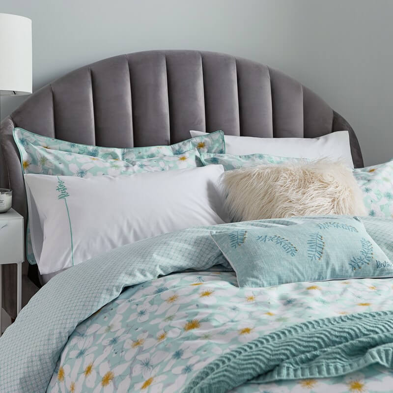 aqua blue cushions set on a blue bedding set in a modern style bedroom