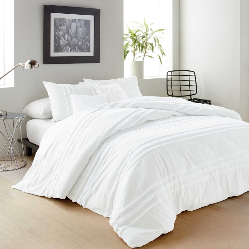 white bedroom with chenile white bedding in an airy and clean bedroom