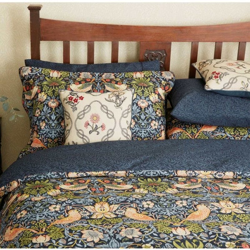 a close up image of the strawberry thief bedding on a bed 
