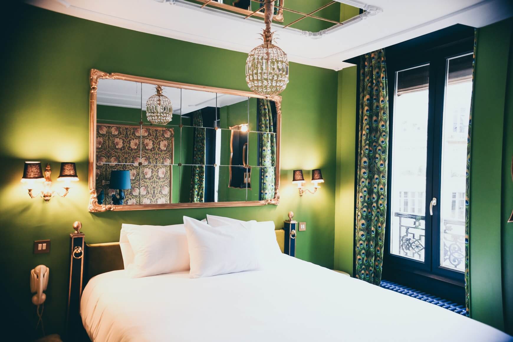 green bedroom with mirrors on the wall