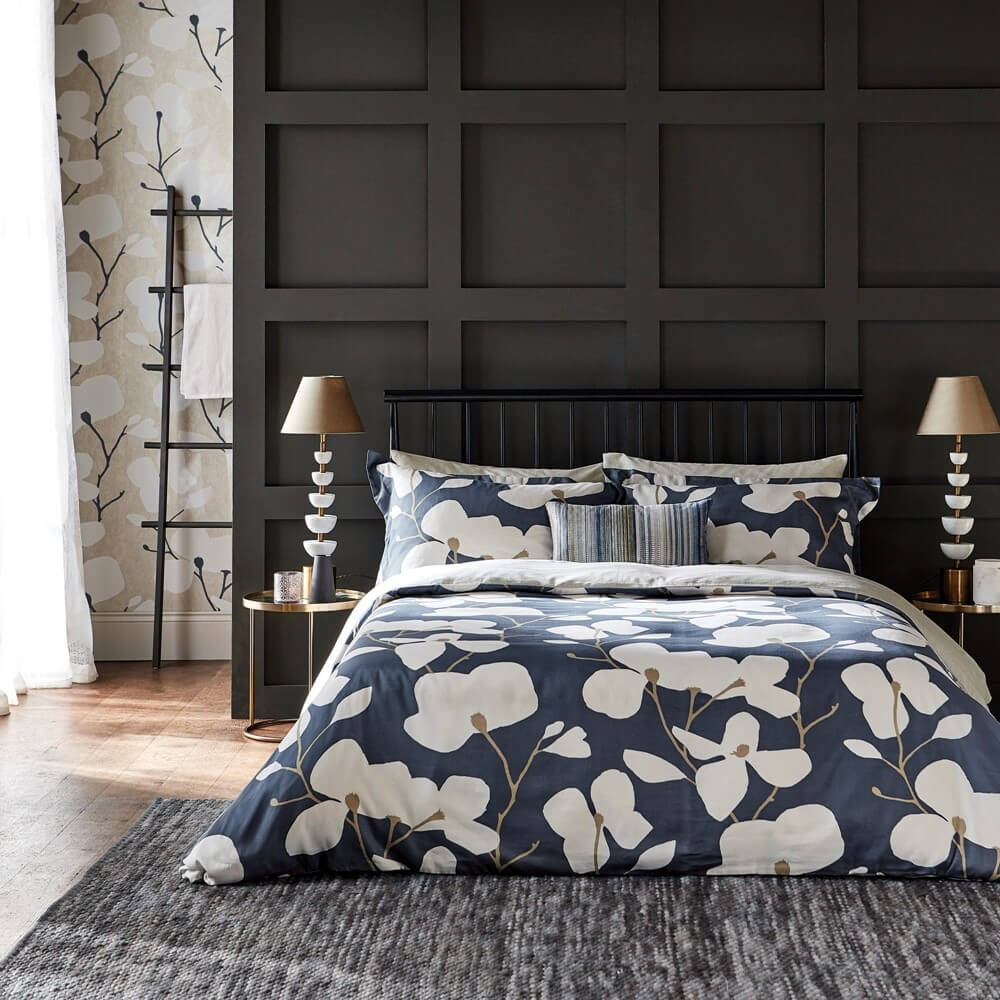 large white floral print on a navy bedding set in a grey minimal bedroom