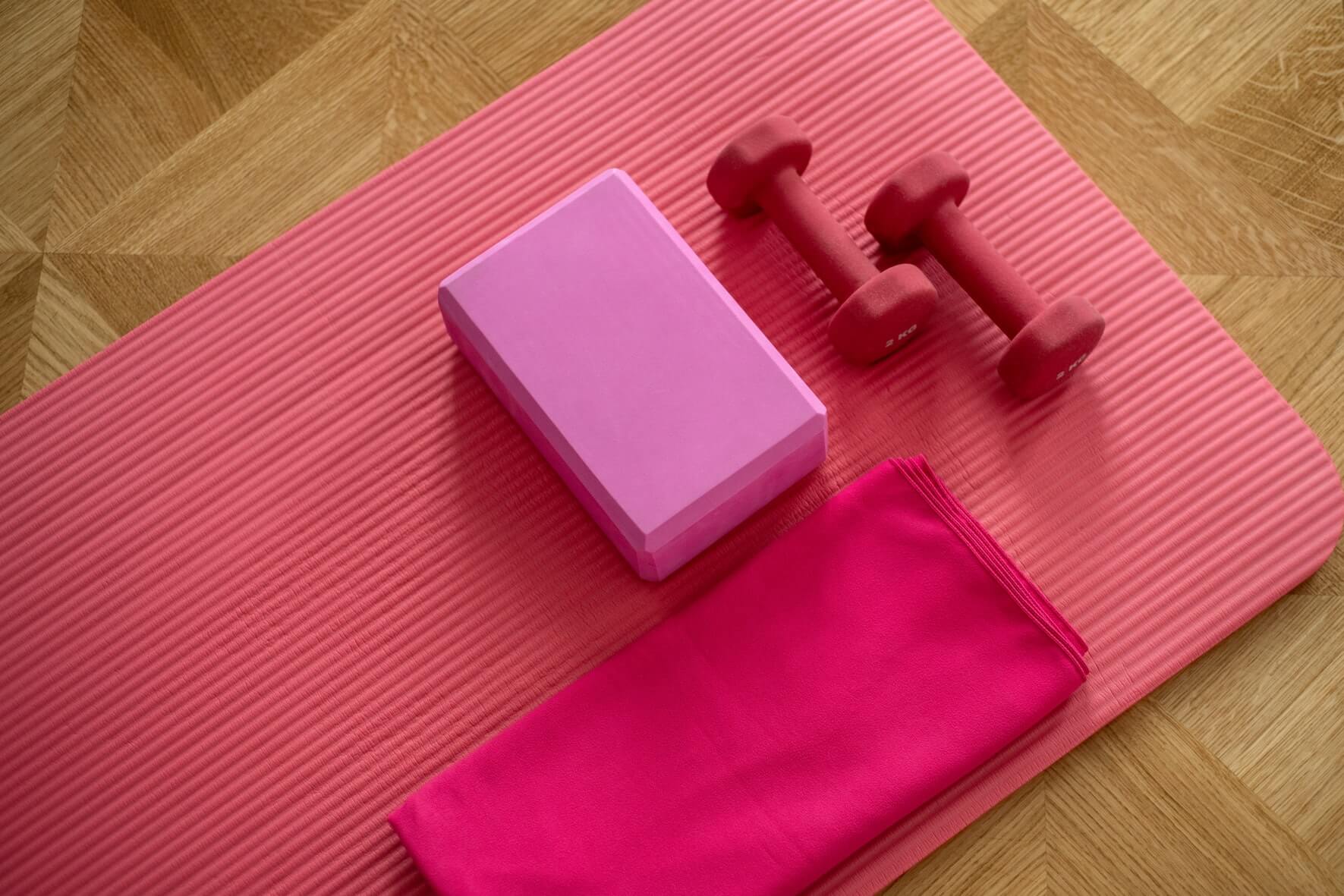 pink yoga mat with weights and towel to use and help you sleep