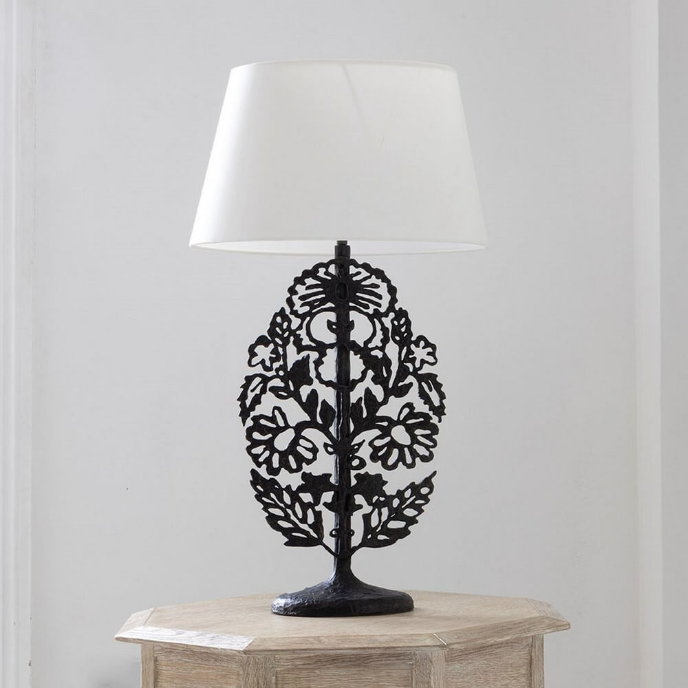 bronze sculptural lamp on a table in a white room