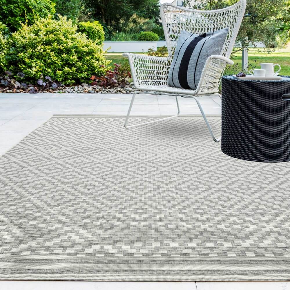 outdoor rug is placed on an outdoor patio in a garden