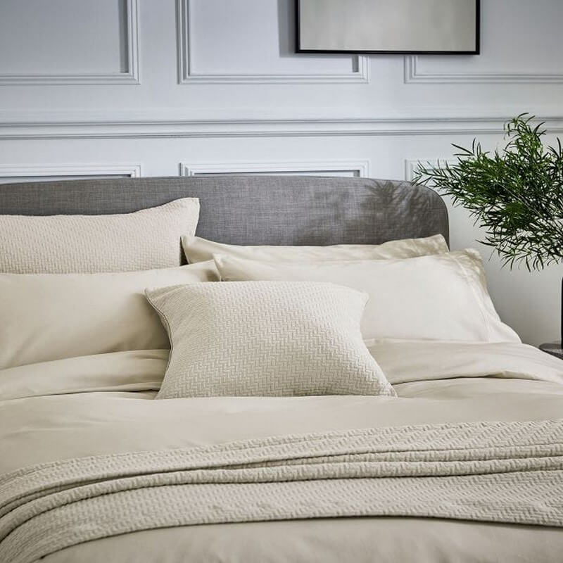 a linen style throw on a bed in a minimal room
