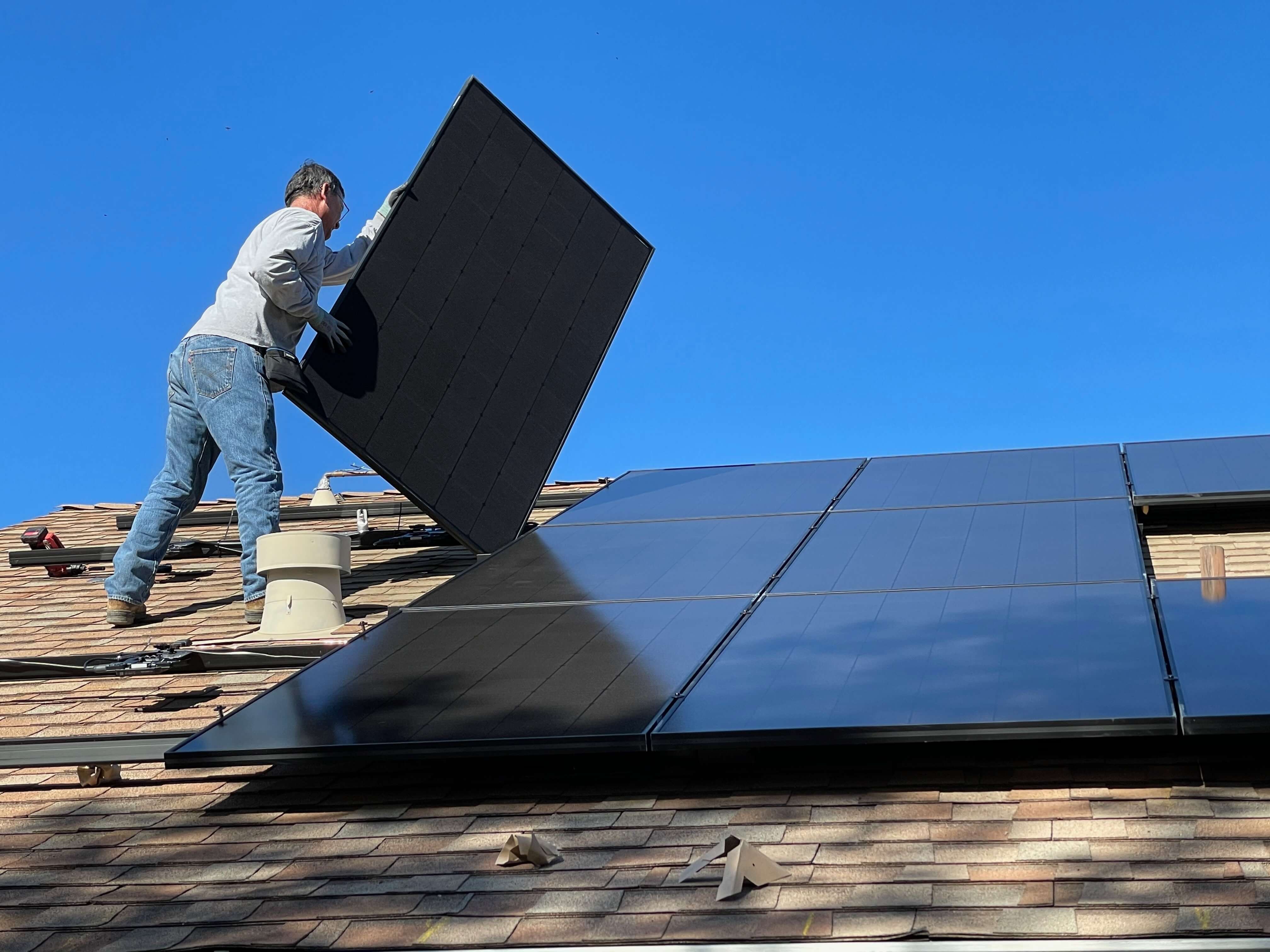 solar panels being placed on a roof of a house