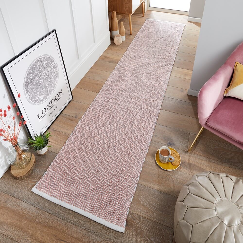 Pink flatweave runner on a wooden floor in a kitchen interior