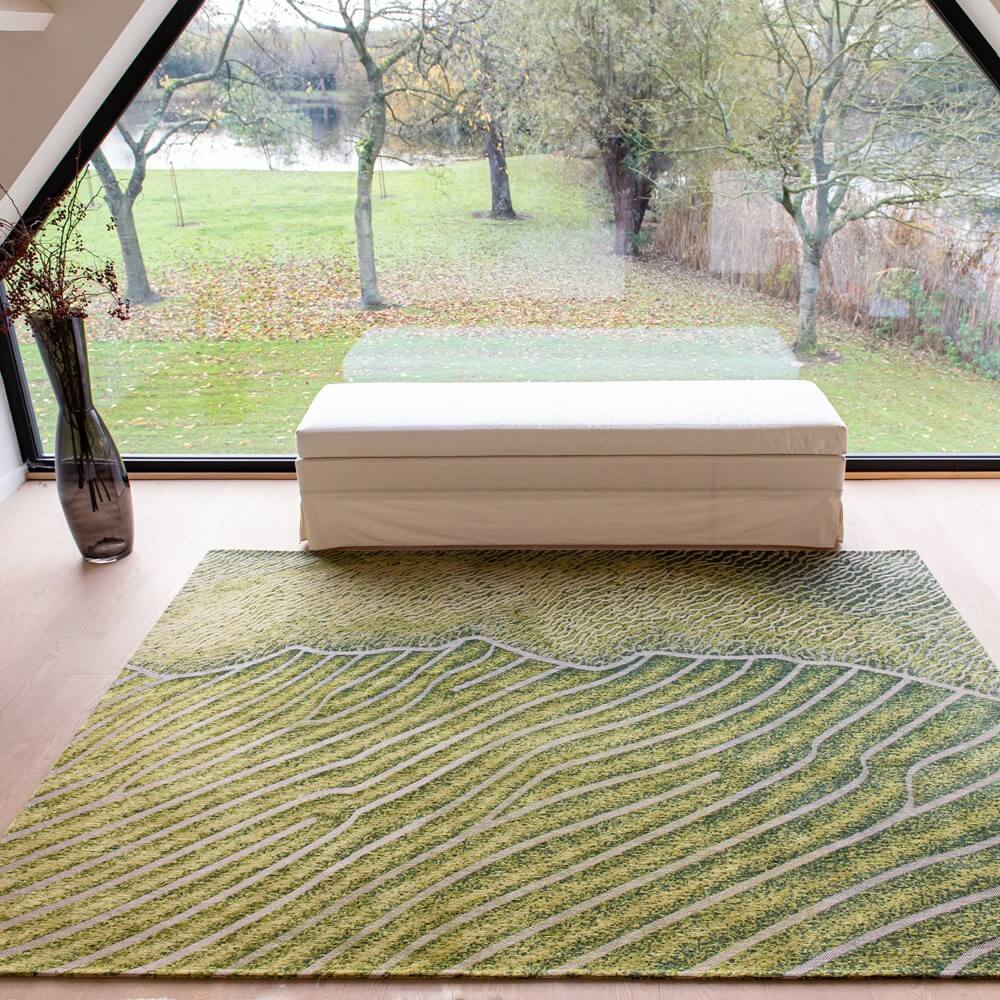 louis de poortere green interior rug on a floor in a living room