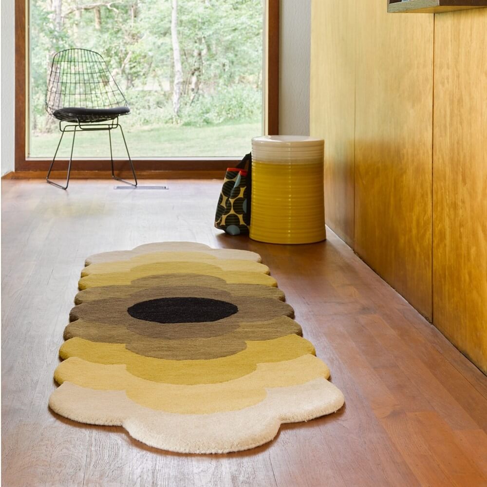an orla kiely optical floral rug placed in a hallway in a 70s style