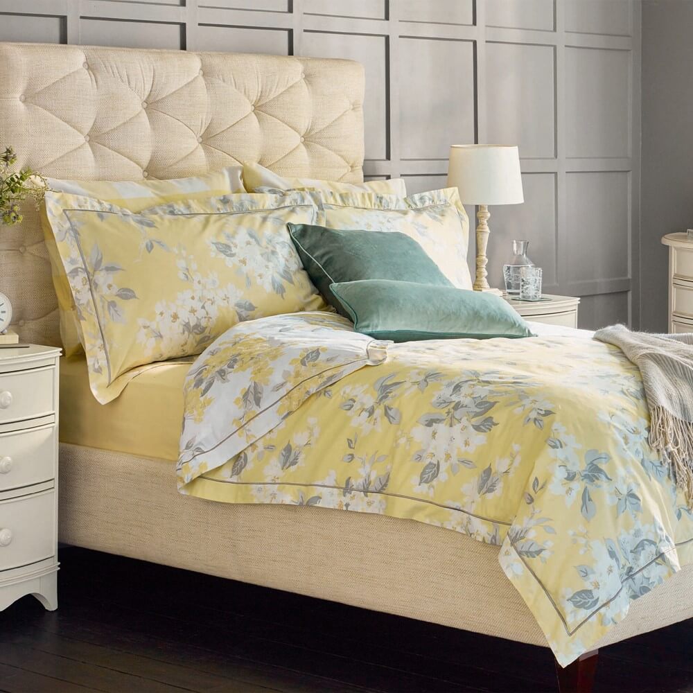 Apple clossom print bedding in yellow on a bed