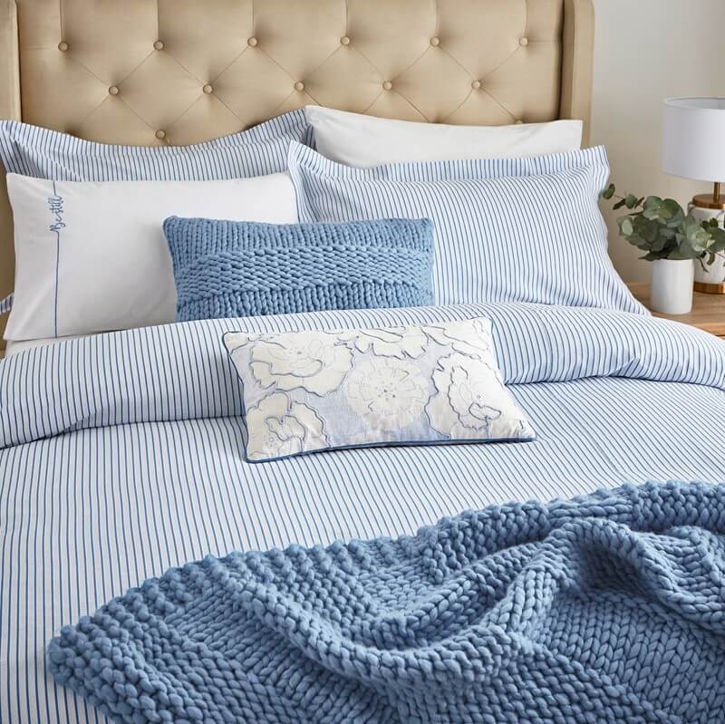 Blue wool knitted throw on the double bed